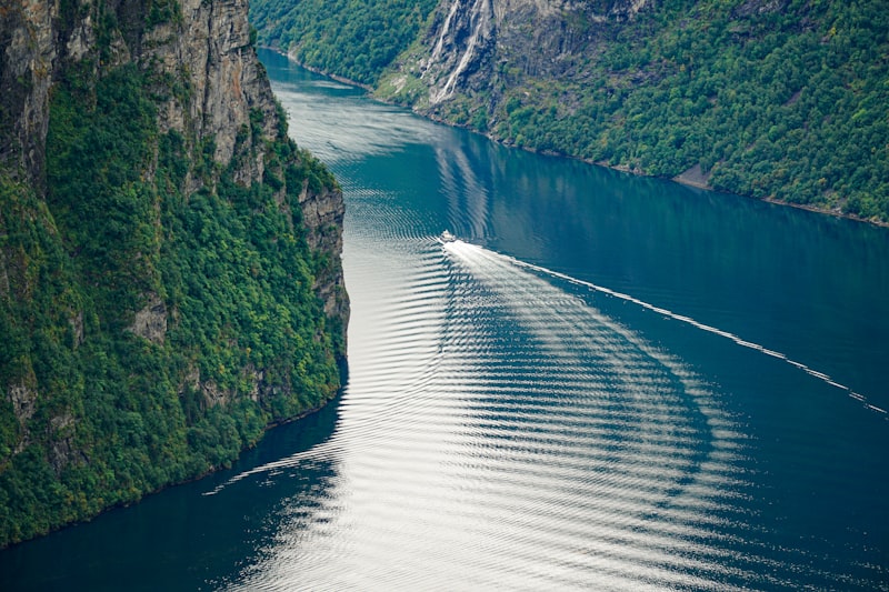 Boat wake cutting through a steep fjord