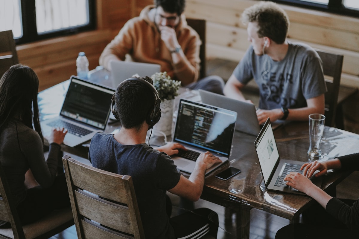 Team working together around a table of laptops