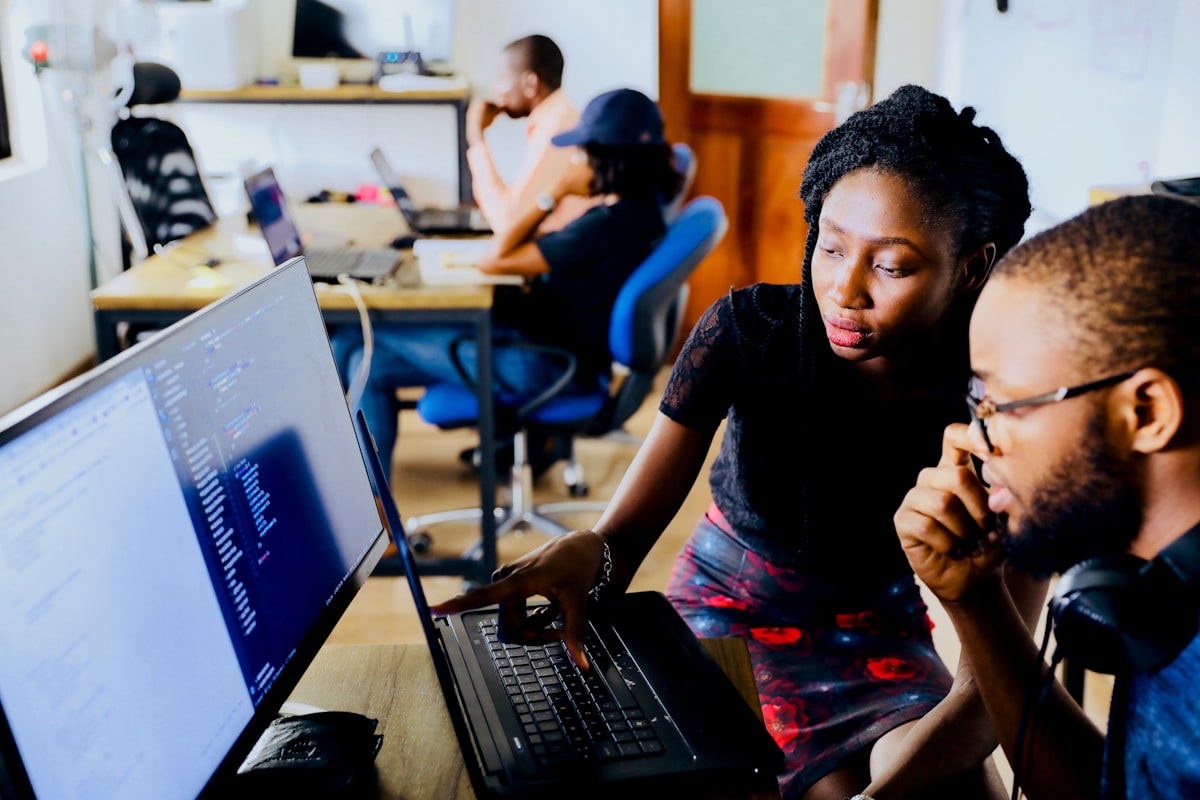 Two colleagues pair programming at a laptop