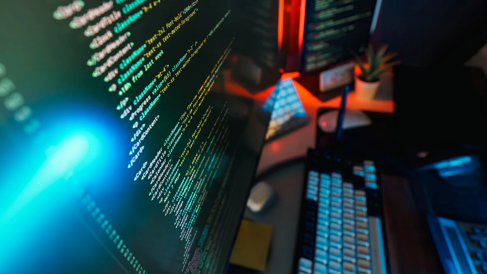 Code displayed across a dark neon workstation