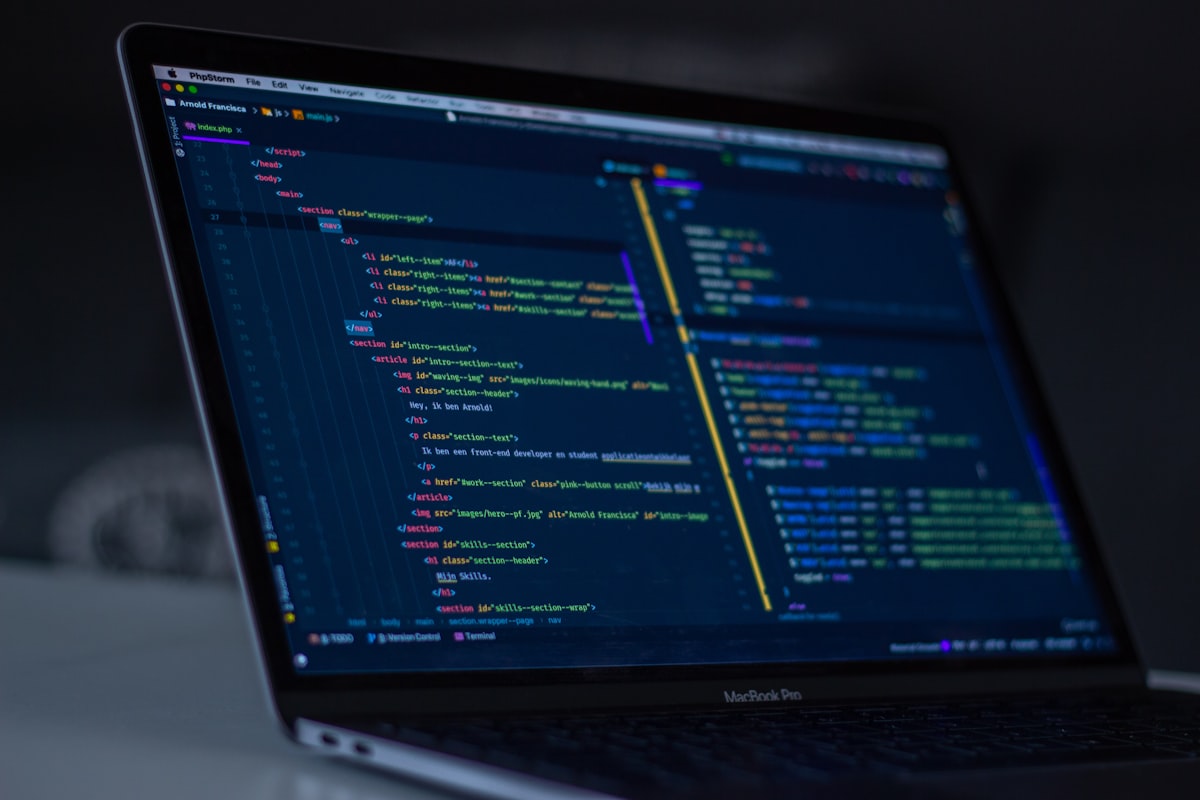 MacBook Pro with a code editor open in a dark room
