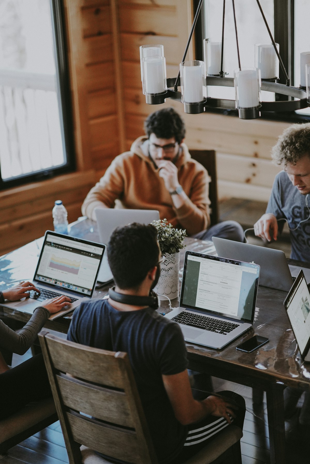 Team collaborating over laptops at a wooden table