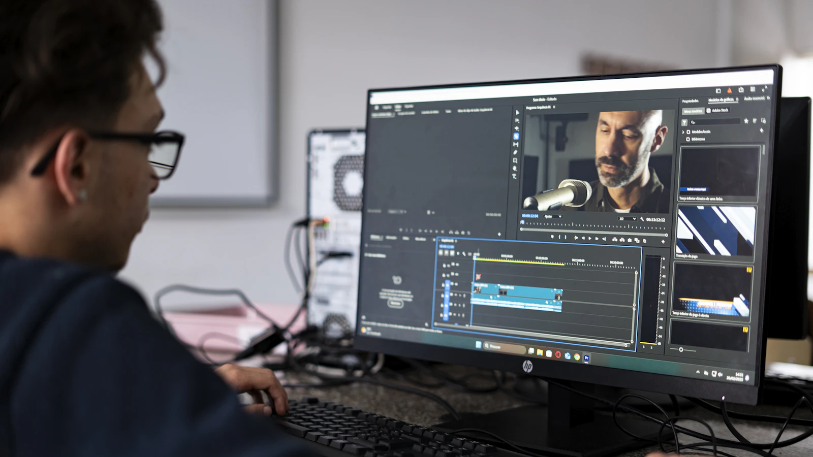 Video editor cutting a creator interview at a workstation